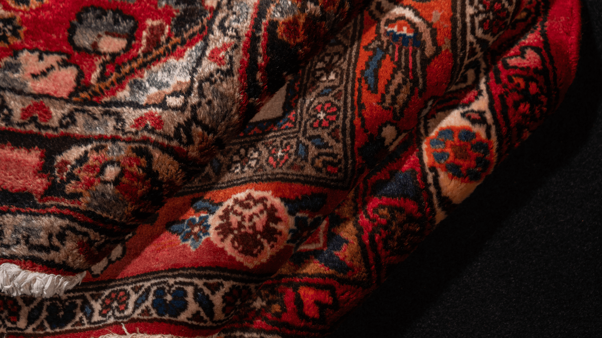 Detail of a folded handwoven Persian carpet